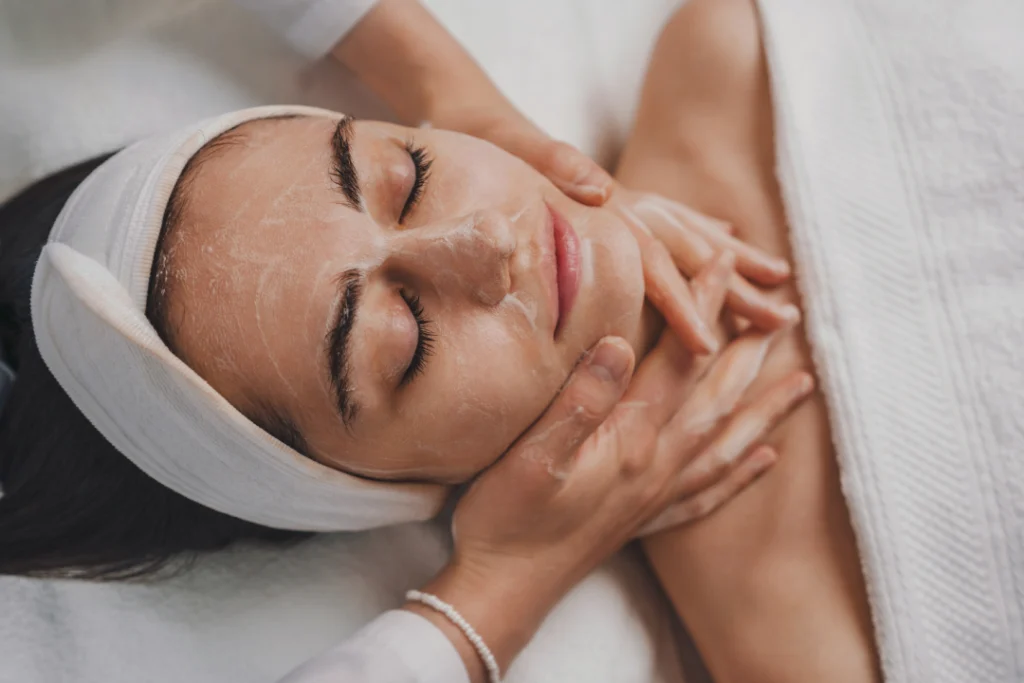 A woman undergoing a facial cleansing and massage for smooth and refreshed skin.